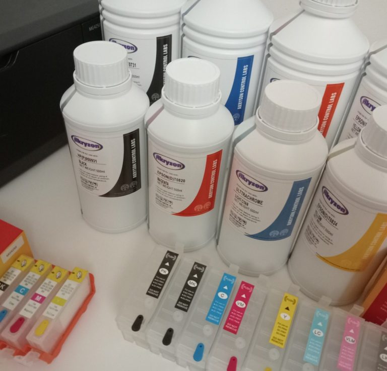 Botellas de tinta y cartuchos de impresora en una mesa.